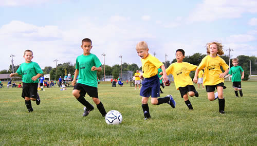 Niños jugando al futbol con su equipo